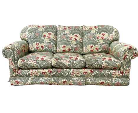 A modern upholstered three piece suite, including a three seat sofa and two deep armchairs, all in red and green floral and e