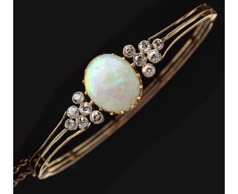Edwardian opal and diamond hinged bangle, the oval cabochon cut white opal displaying violet, blue, green, yellow, orange and