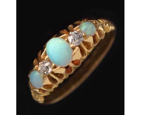 Late Victorian opal and diamond 18ct yellow gold ring, the oval cabochon cut white opal to centre displaying blue, green, yel