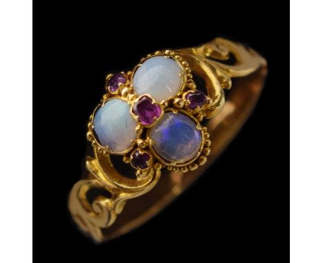 Early 19th century opal and ruby yellow metal ring, three cabochon cut white opals displaying blue and green play of colour, 