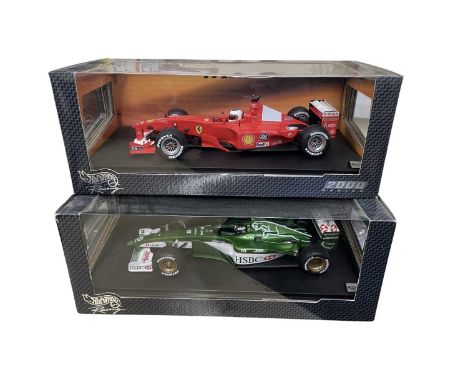 A pair of boxed Hotwheels 1:18 scale model racing cars, to include: - F1-2000, Rubens Barrichello - Jaguar, Eddie Irvine