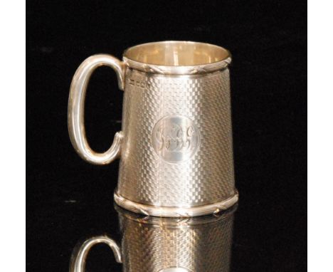 A hallmarked silver christening tankard with engine turned decoration to whole, terminating in plain C scroll handle, weight 