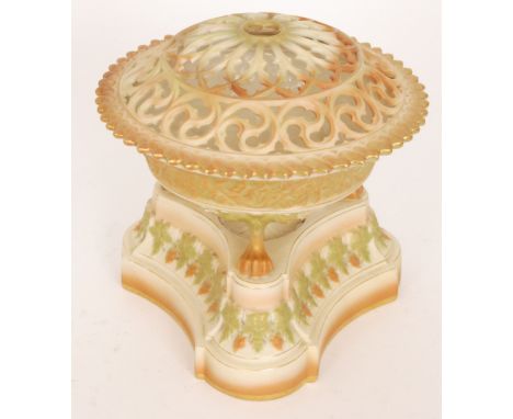 An early 20th Century Royal Worcester blush ivory pot pourri, the body formed as a conical bowl raised to three claw feet wit