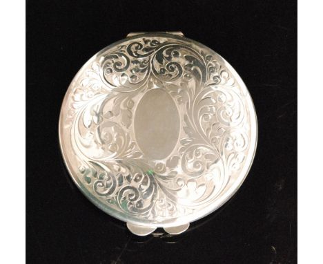 A hallmarked silver circular compact with foliate engraved decoration to hinged cover, diameter 8cm, complete with fittings, 