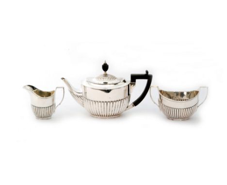 An Edwardian hallmarked silver three piece tea service with part fluted decoration, weight 27oz, London 1903, William Hutton 