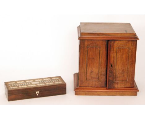 A Victorian walnut smokers cabinet fitted with three drawers enclosed by a pair of inlaid doors and a cribbage box, width 29c