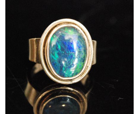  A 1990s hallmarked  9ct opal dress ring, the oval setting with an opal doublet, later mounted to a plain tapering band, Lond