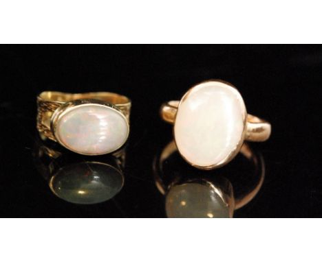 A 9ct rose gold dress ring collar set with an opal cabochon to a plain band, and another smaller yellow gold example, stamped