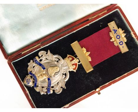 A cased hallmarked silver Masonic jewel Earl of Warwick Lodge No 523 with part gilt and blue enamel decoration below red silk
