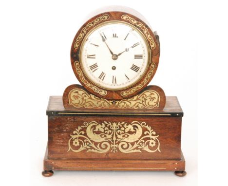 A late Regency brass inlaid mantle clock, the circular painted dial above a rectangular plinth decorated with two fish amidst