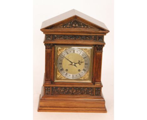 A Victorian oak mantle clock of architectural form, with eight day striking movement on stepped plinth base, height 44cm