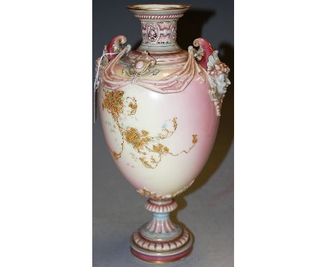 A Royal Worcester glazed porcelain twin handled pedestal vase of baluster form, the masked handles over floral gilt applied t