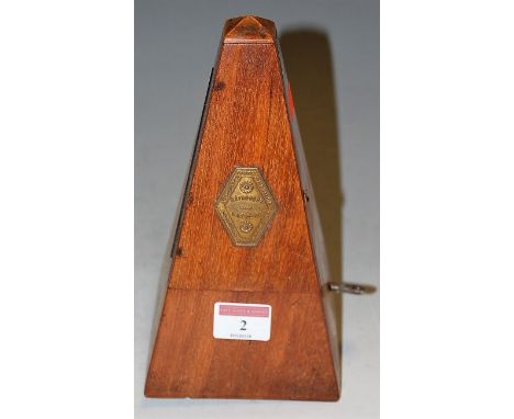 An early 20th century walnut cased metronome with hexagonal brass label