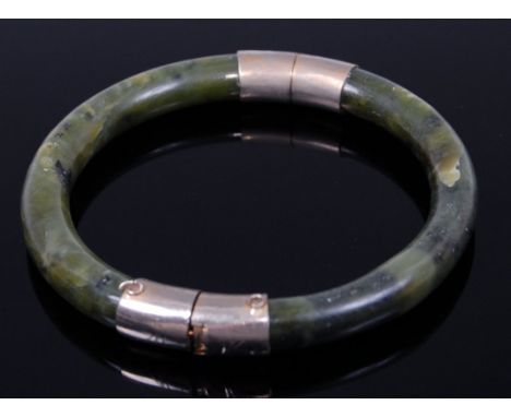 A green hardstone and white metal hinge bangle