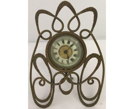A vintage enamelled face desk clock in ornate metal mount.  