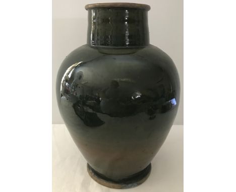 A large ceramic vase with green glaze and metal rim to top and bottom.  Approx.  40cm tall.