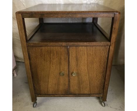 A 1960's wooden trolley / cabinet with record storage double door cupboard to base and shelf to top. On ball castors. Approx.