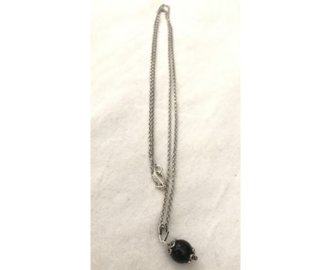 A boxed silver and black onyx Su Coccu pendant and chain. Su Coccu is an ancient Sardinian amulet worn to protect against the