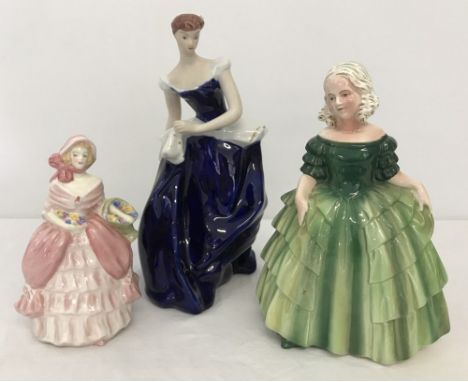 A Royal Dux figurine of a lady in a blue dress with a spotted handkerchief. Together with 2 other ceramic figurines. 