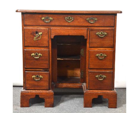 George III mahogany kneehole desk, the top with rounded corners and moulded edge, eight drawers surrounding a cupboard, brack