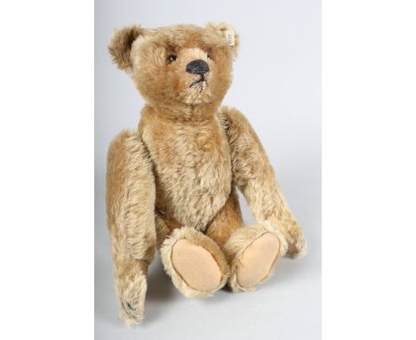 A Steiff early 20th century beige mohair, articulated and wind up bear, with original chrome button and tag 9332 in his right