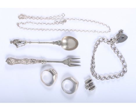 A white metal coffee spoon with figure finial, a silver pickle fork, two silver rings, a silver bracelet and other silver ite