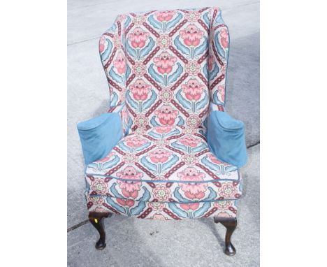 A wing armchair with needlework upholstery, a companion with printed cover and a matching stool