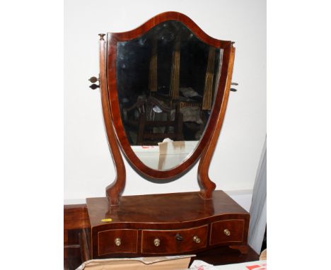 A Georgian mahogany shield-shaped dressing table mirror with serpentine front fitted three drawers, on bracket feet