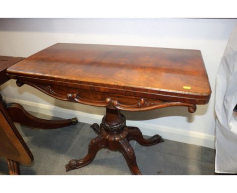 A 19th century rosewood fold-over top card table with red baize playing surface, on turned column and four splayed supports