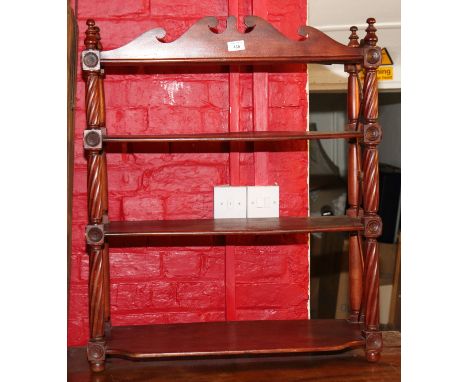A 19th century mahogany four-tier open wall hanging shelf with shaped crest, 28" wide