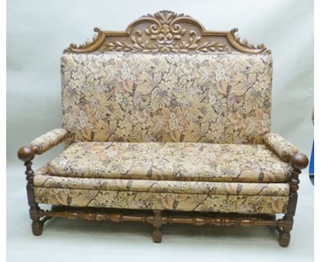 A 19TH CENTURY OAK JACOBEAN DESIGN SETTLE BENCH having carved green man effect panelled crest, floral tapestry effect fabric 