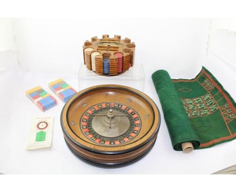 A 20TH CENTURY EBONISED WOOD ROULETTE WHEEL, 37cm diameter, together with a wooden rotating chip holder with brass handle, a 