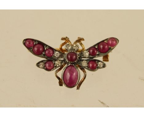AN EDWARDIAN STYLE GOLD COLOURED METAL SET RUBY AND DIAMOND BROOCH fashioned as a butterfly with ten rubies and eight diamond
