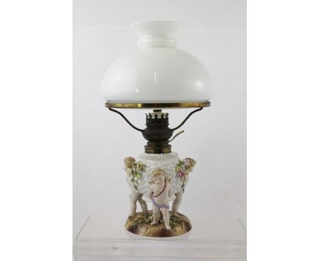 AN EARLY 20TH CENTURY SITZENDORF PORCELAIN TABLE LAMP, having opal glass shade, basket reservoir moulded with three supportin