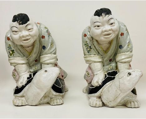 A pair of Chinese Figures riding on the back of tortoise 
