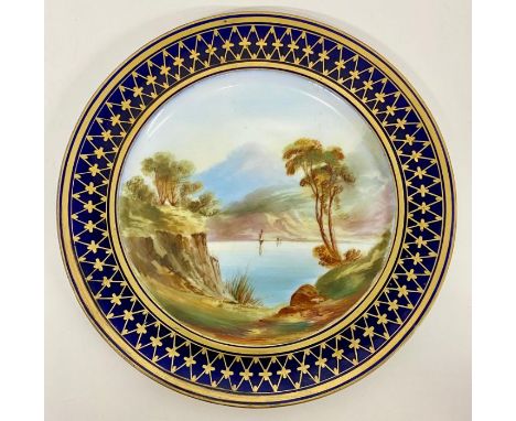 A mid 19th Century hand decorated Worcester style plate with blue and gilt border and lake scene to