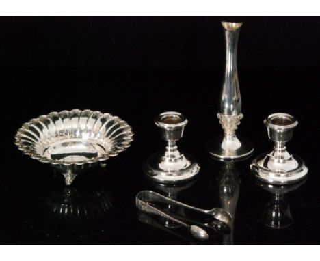 A pair of hallmarked silver squat candlestick, a bud vase, a small circular dish raised on three feet, sugar tongs and a bud 