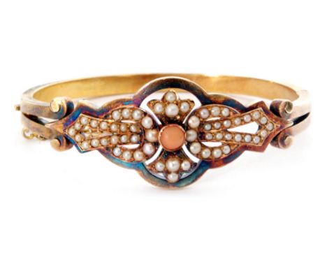 A 19th Century 15ct seed pearl and coral hinged bangle with central collar set coral flanked by pearl set pierced panels and 