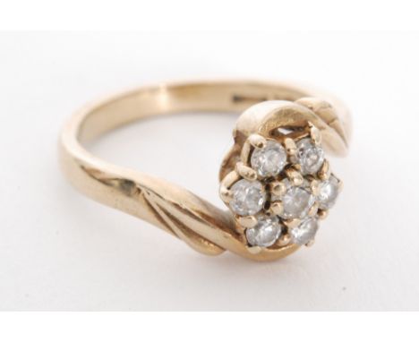 A 9ct diamond daisy cluster ring, seven claw set brilliant cut stones to a slight twist, ring size K 1/2. 