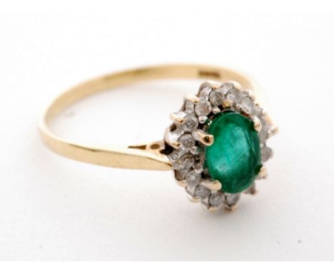 An 18ct emerald and diamond cluster ring, central oval emerald within a sixteen stone diamond surround, all stones claw set t