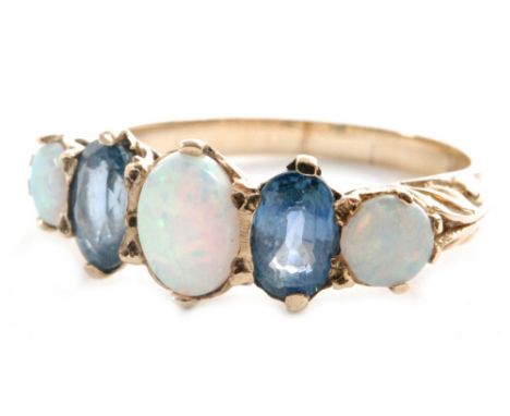 A 9ct hallmarked five stone blue topaz and opal ring, three opals spaced by topaz to foliate detailed shoulders, ring size P.