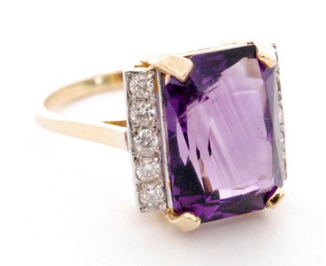 An 18ct hallmarked amethyst and diamond ring, central claw set emerald cut amethyst flanked by a single row of vertically fiv