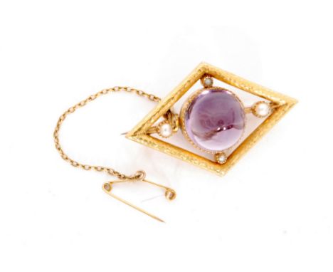 An early 20th Century 15ct amethyst and seed pearl brooch of central cabochon cut amethyst within gold lozenge shaped border 
