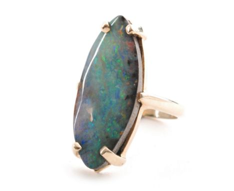 A 9ct hallmarked oval boulder opal to a four claw setting and plain shoulders, length of stone 27mm, ring size O 1/2. 