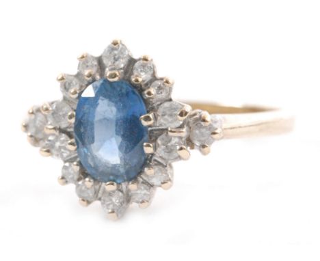 A 9ct hallmarked sapphire and diamond cluster ring, central oval sapphire within a fourteen stone diamond surround with a sin