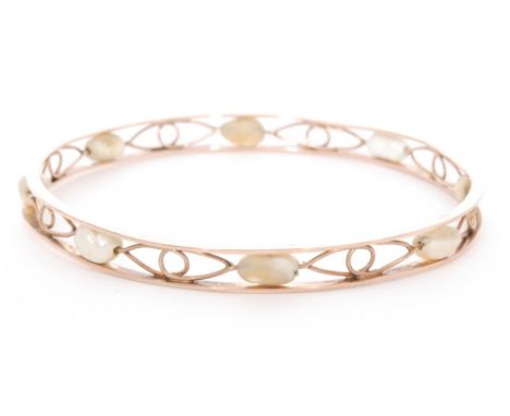 A 9ct rose gold slave bangle with pierced fretwork design interspersed with freshwater pearls, weight 14.3g, inner diameter 2