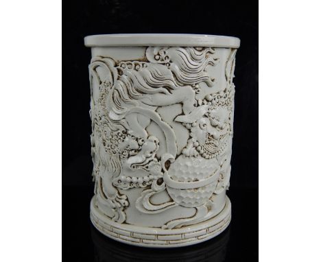 Chinese blanc de chine brush pot, decorated with temple lions playing with an embroidered ball, seal stamp to base, 14cm h