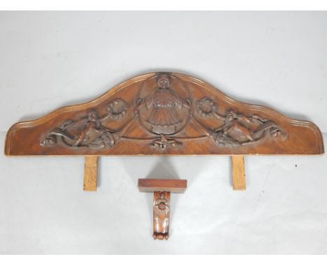 Early 20th century carved walnut panel, of serpentine form incorporating a figure and cherubs, 116cm w, and a small wall brac
