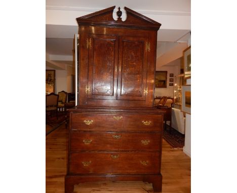 George III and later oak housekeepers cupboard, the upper section with a broken cornice above a pair of panel doors enclosing