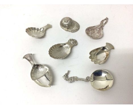 Seven sterling silver caddy spoons, 1916 and later, including jockey cap, seahorse, hand, acorn, etc